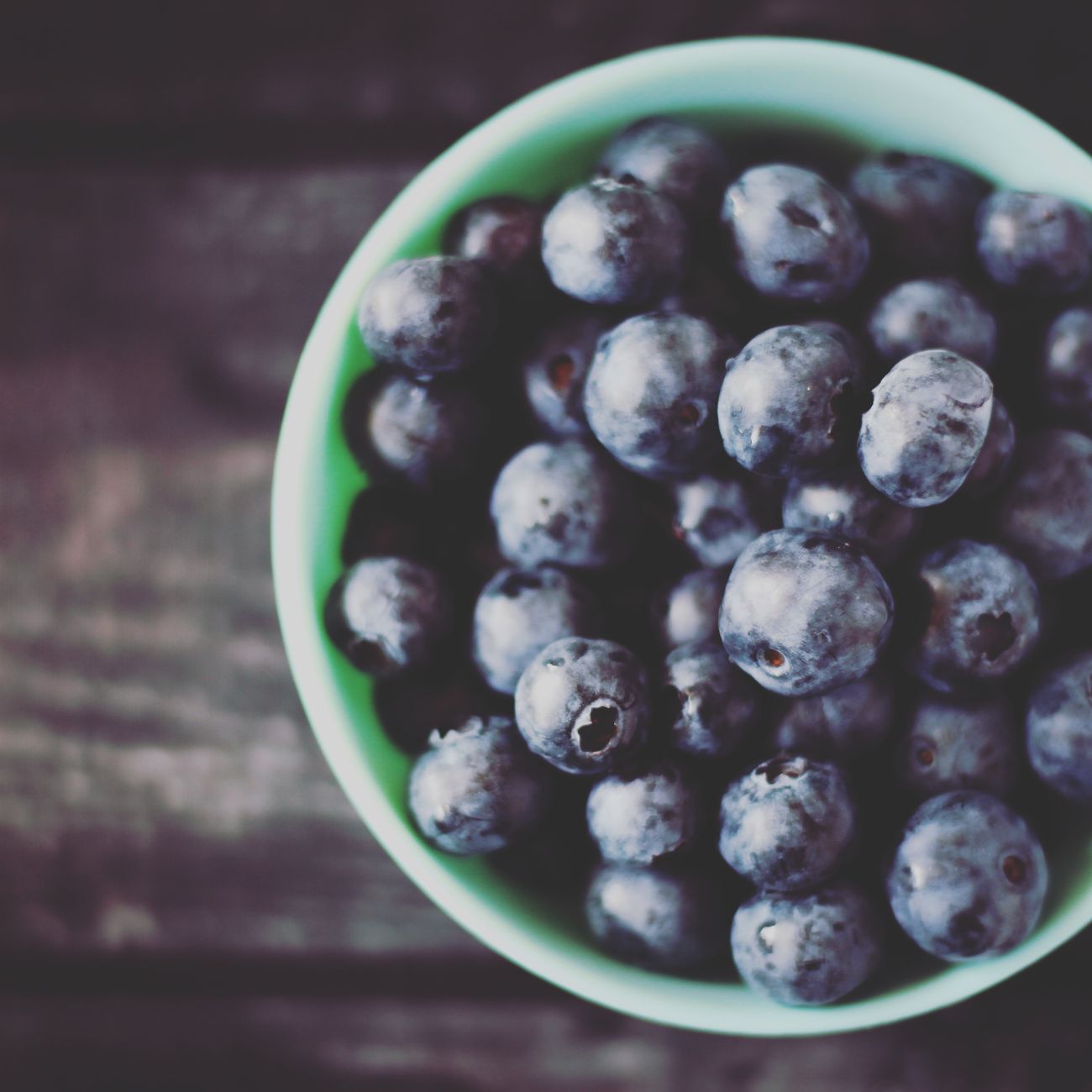 Bowl of blueberries on a rustic wooden board