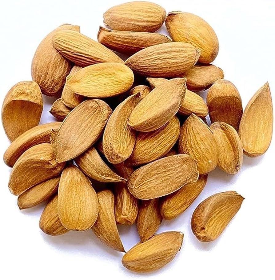 A heap of whole Kashmiri almonds on white