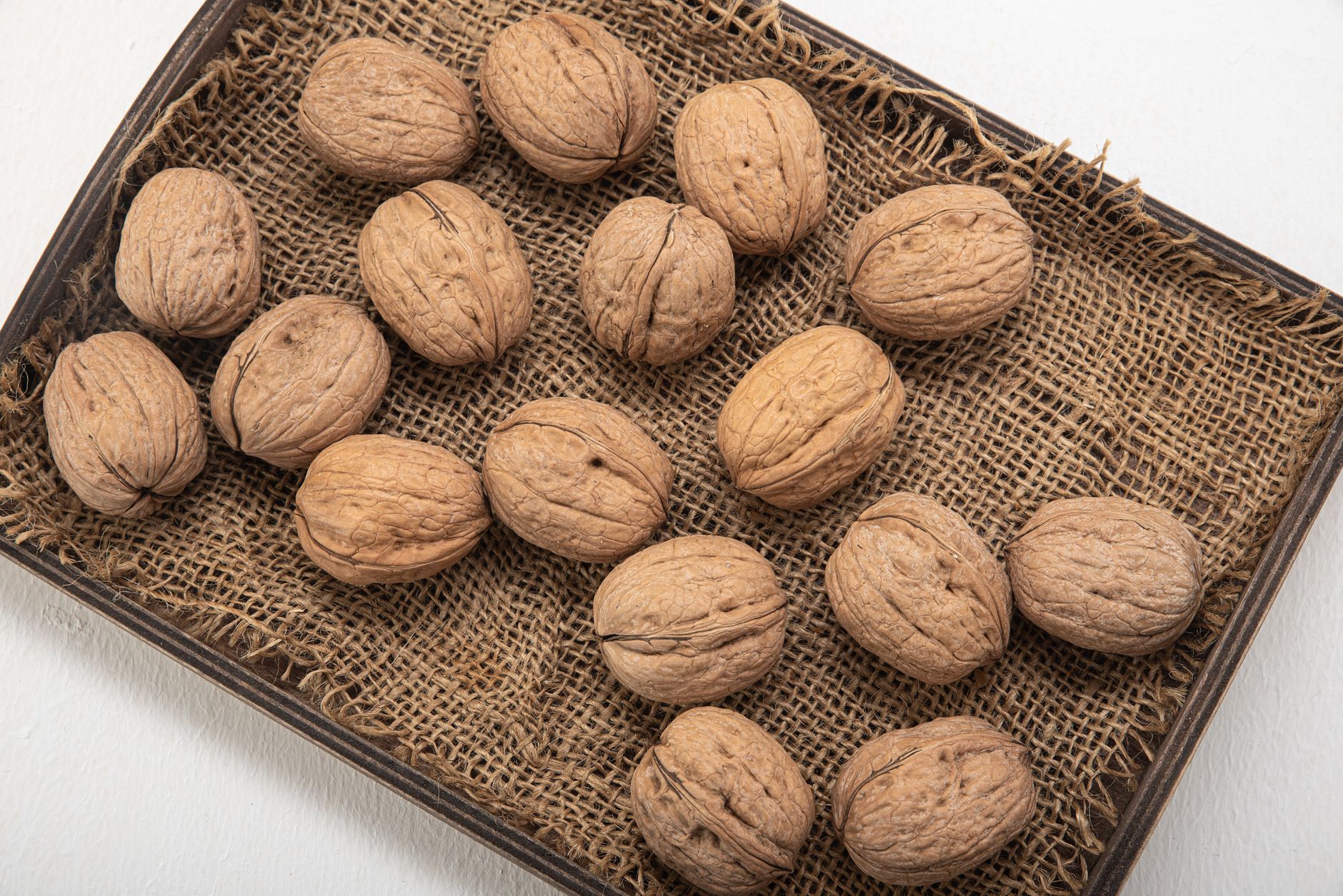 Walnuts in shell laid out on hessian
