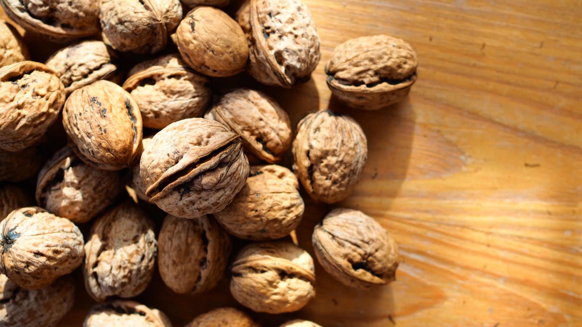Walnuts scattered across a wooden table